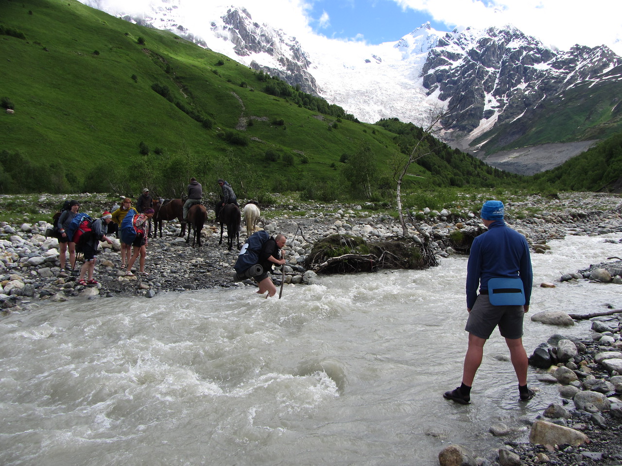 Брод через ледниковую реку. Инструктор помогает группе